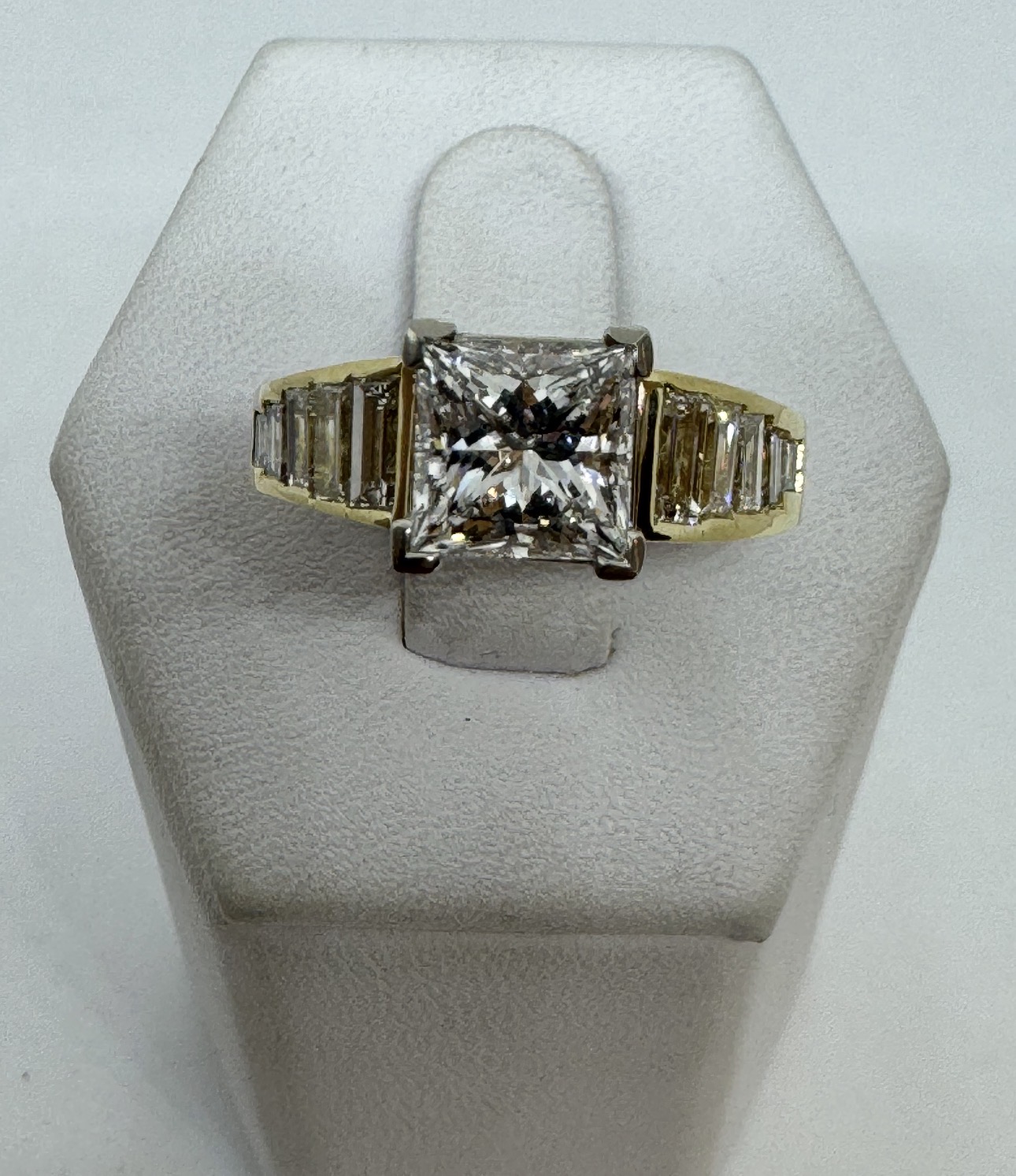 Princess-cut diamond engagement ring with baguette side stones in yellow and white gold