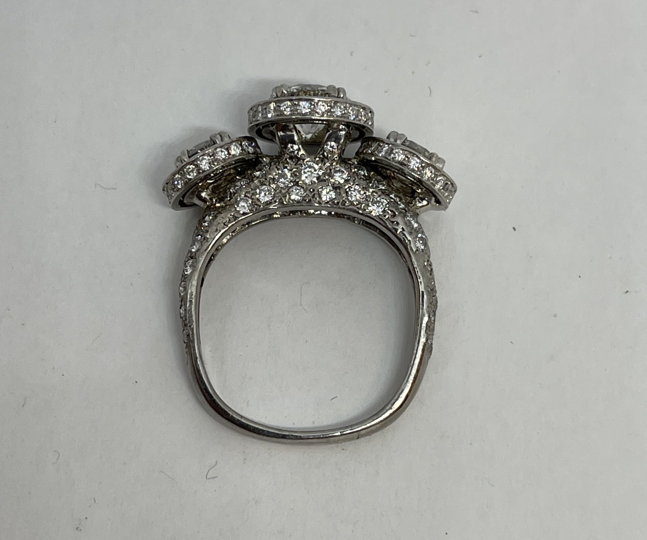 Three-stone diamond halo ring in white gold — custom engagement work by Michael W. Hayes